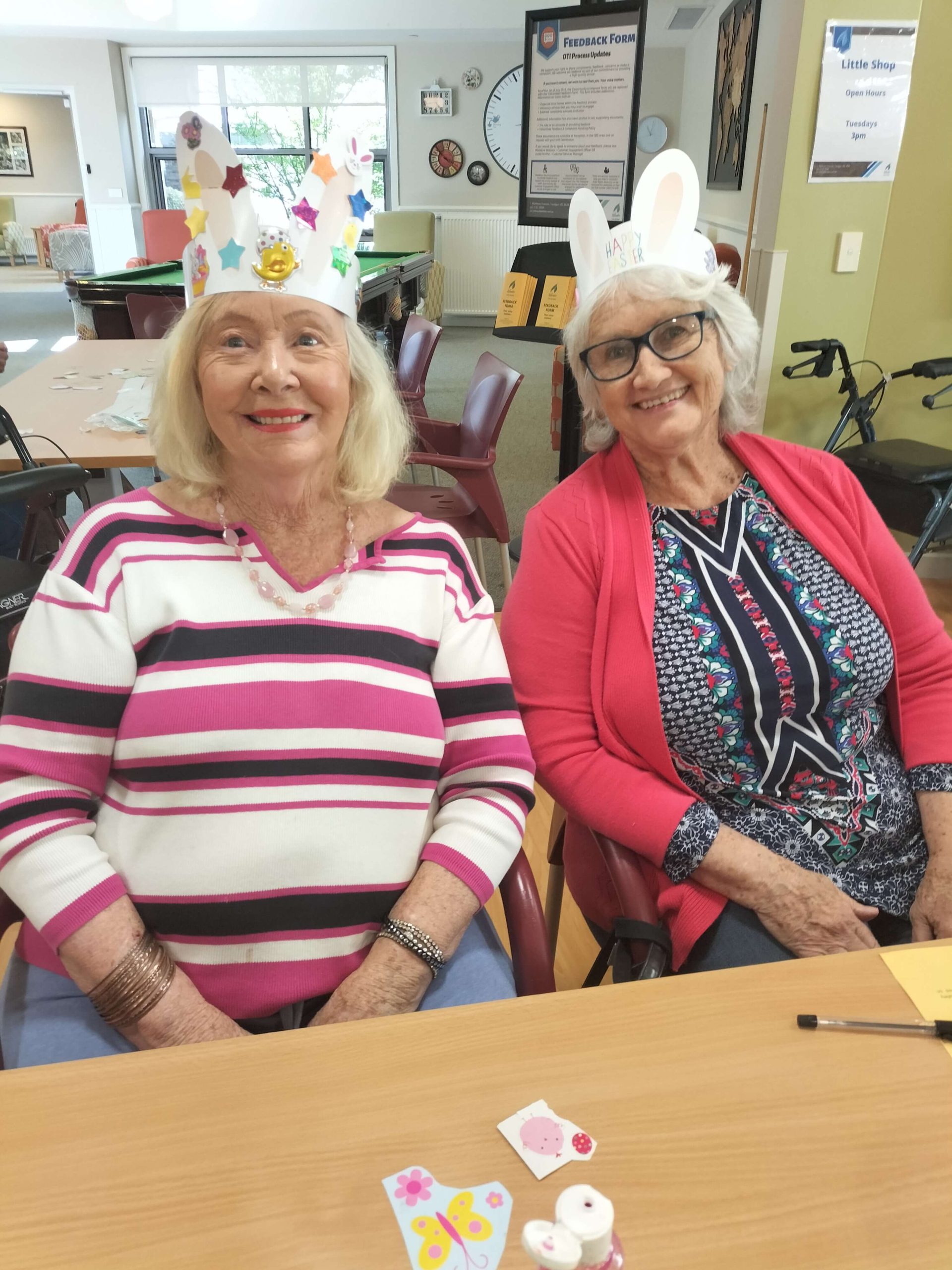 Photo of two elderly ladies wearing hand made Easter bonnet hats made from paper and craft.