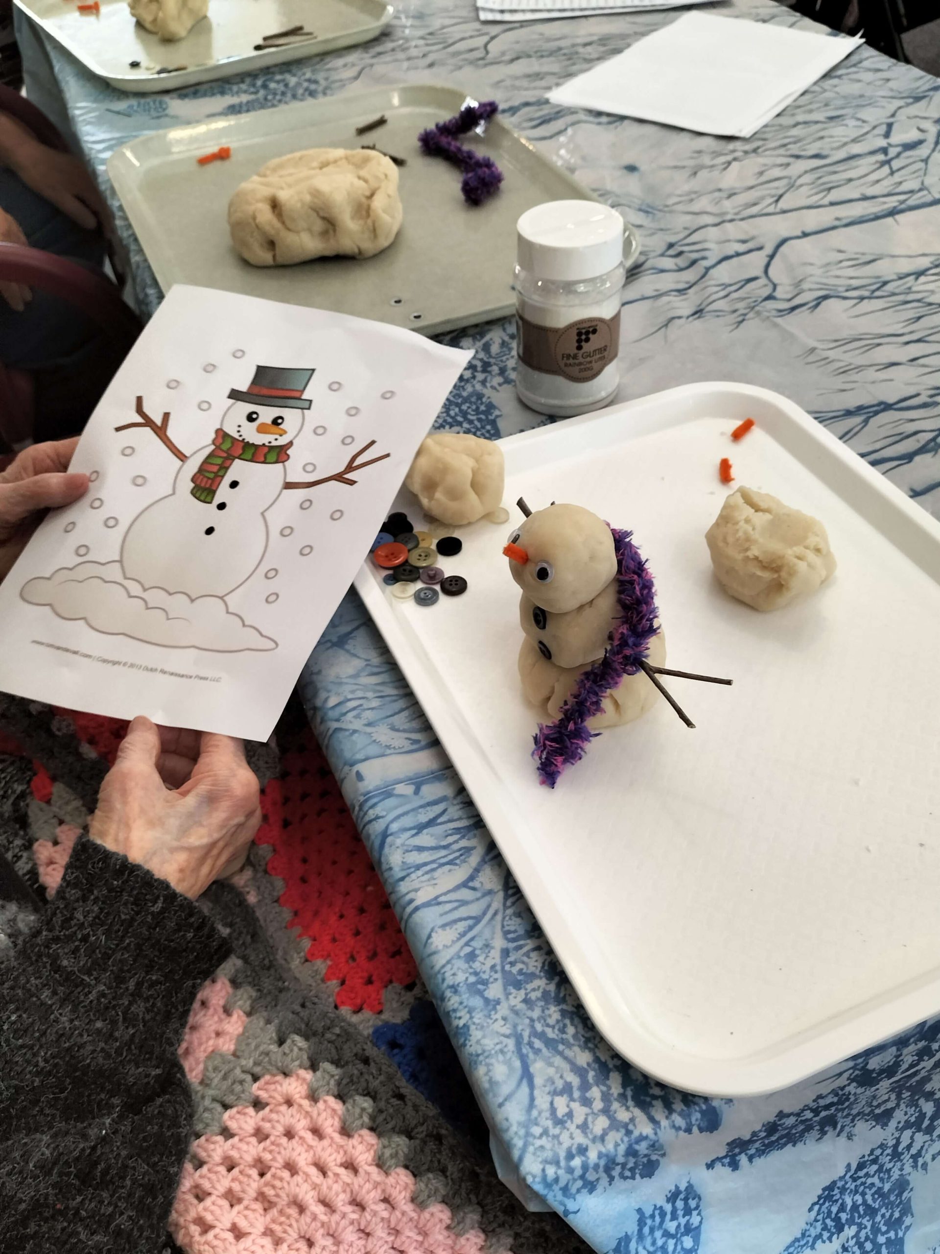 Photo of craft activity at Yallambee Aged Care, making snowman out of dough and decorating it.