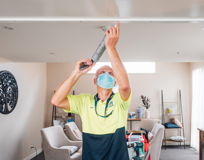 Photo of a tradesman fixing a ceiling crack